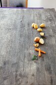 Kartoffeln, Butter, Zwiebel, Möhren und Lorbeerblätter auf Holzuntergrund