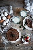 Schokoladenpfannkuchen mit Zutaten auf rustikalem Holztisch (Aufsicht)