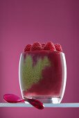 Matcha chia pudding with raspberry puree in a glass