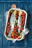 Trouts baked with potatoes, cherry tomatoes and lemon