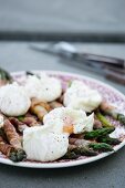 Green asparagus wrapped in bacon with eggs benedict