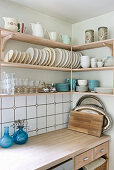 Plate racks and blue crockery on wall-mounted kitchen shelves
