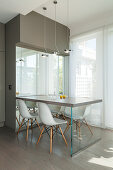 Breakfast table and classic chairs next to glass wall in designer kitchen