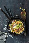 Pasta with leek, bacon and cranberries in a frying pan