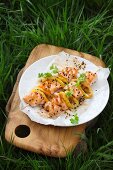 Salmon skewers on a plate outdoors