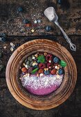 Berry smoothie bowl with hazelnuts, pumpkin seeds and oat flakes