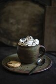 Cocoa with soy cream, grated chocolate, and a biscuit (vegan)