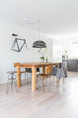 Wooden table and various vintage chairs on pale wooden floor