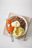 Lunch Bowl mit Möhrenspiralen, Avocado, pochiertem Ei und Linsen