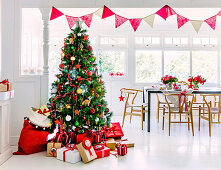 Wrapped presents around the Christmas tree in front of the dining table