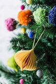 Plisseeornament und bunte Pompoms als Christbaumschmuck