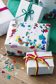 Colorfully wrapped presents with confetti and colored strings