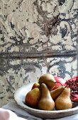 Pears and pomegranates in a stone bowl