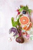 A still life with beetroot, figs, grapefruit, radishes, and red cabbage