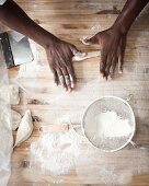 A pair of hands rolling out dough