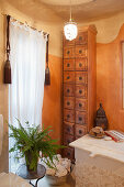 Tall, wooden chest of drawers in two-tone bathroom