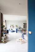 Blaue Schiebetür zum offenen Wohnraum mit Sofa und Esstisch