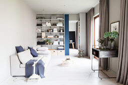 Living room in shades of grey with shelves and sliding door
