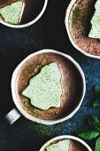 Kakao in Tassen dekoriert mit grünen Matcha-Marshmallows in Tannenbaumform