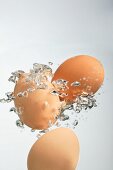Brown eggs surrounded by bubbles in water