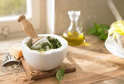 Pesto in a mortar, parmesan, olive oil and pasta