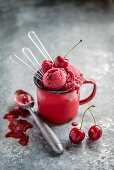 Cherry sorbet in an enamel cup with spoons