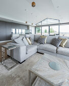 Patterned scatter cushions on grey sofa in large open-plan interior