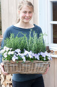 Woman bringing basket with Rosemary (Rosemary) and Viola