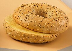 A toasted bagel with sesame and poppy seeds, sliced