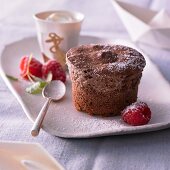 Chocolate souffle with raspberries and icing sugar