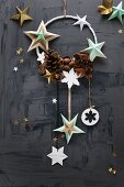 Weihnachtsdeko an einem Ring mit Sternen und Zapfen