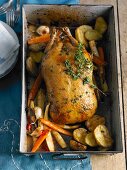 Herb duck in an oven dish with vegetables