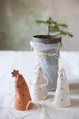 Perforated pottery bells in front of tiny potted fir tree
