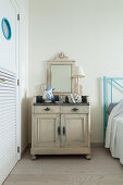 Vintage accessories on old, shabby-chic cabinet used as bedside table