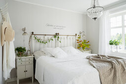 Wall tattoo above bed in vintage bedroom painted white