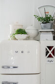 Soup tureens, plants and scales on top of fridge and cupboard