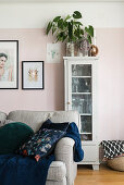 Zimmerpflanze auf einer Vitrine an rosafarbener Wand im Wohnzimmer