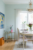 Antique Swedish dining table, chairs and serving trolley in dining room with mint-green walls