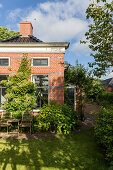 Summery garden around small brick house