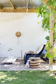 Chairs and DIY table on castors on roofed terrace with white wall