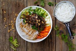 A Thai bowl with rice noodles, vegetables and peanuts