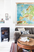 Log burner next to sofa and coffee table in living room with white wooden floor