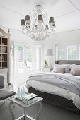 Kronleuchter im eleganten Schlafzimmer in Grau und Weiß