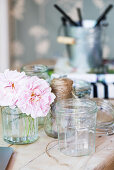 Preserving jars and pink flowers on wooden table