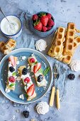 Waffles with cream, raspberries, strawberries, blackberries and mint