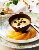 Saffron mousse with pistachios in a chocolate bowl for Christmas