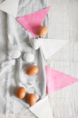 Brown eggs and white, speckled eggs, feathers and bunting