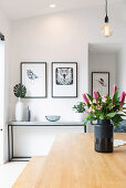 Bouquet of flowers in black vase on the wooden table in the dining room