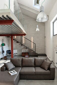 Grey couch in industrial loft apartment with gallery