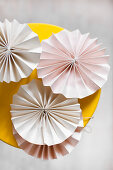 Pale pink paper rosettes on yellow stool